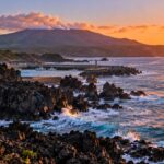 三宅島の夜明けの黒い溶岩海岸と小さな港
